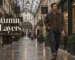 Man in a brown knitted polo, olive jacket and dark denim walking through a Cardiff arcade