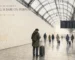 Watercolour of a London station concourse with a bare wall where luggage lockers once stood